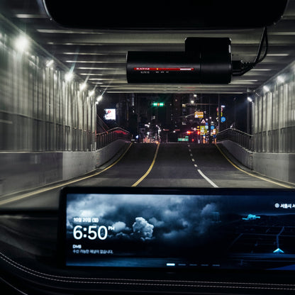 Car interior view from a vehicle driving through a tunnel with a digital display showing the time.