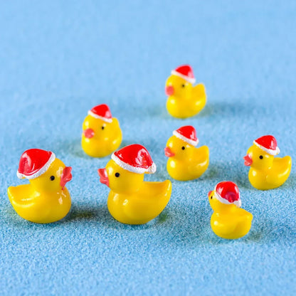 Small yellow rubber ducks wearing red Santa hats on a blue background