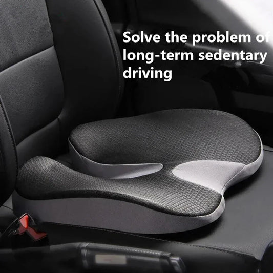 A black and gray contoured car seat cushion shown installed on a car seat, with white text overlay reading 'Solve the problem of long-term sedentary driving'.
