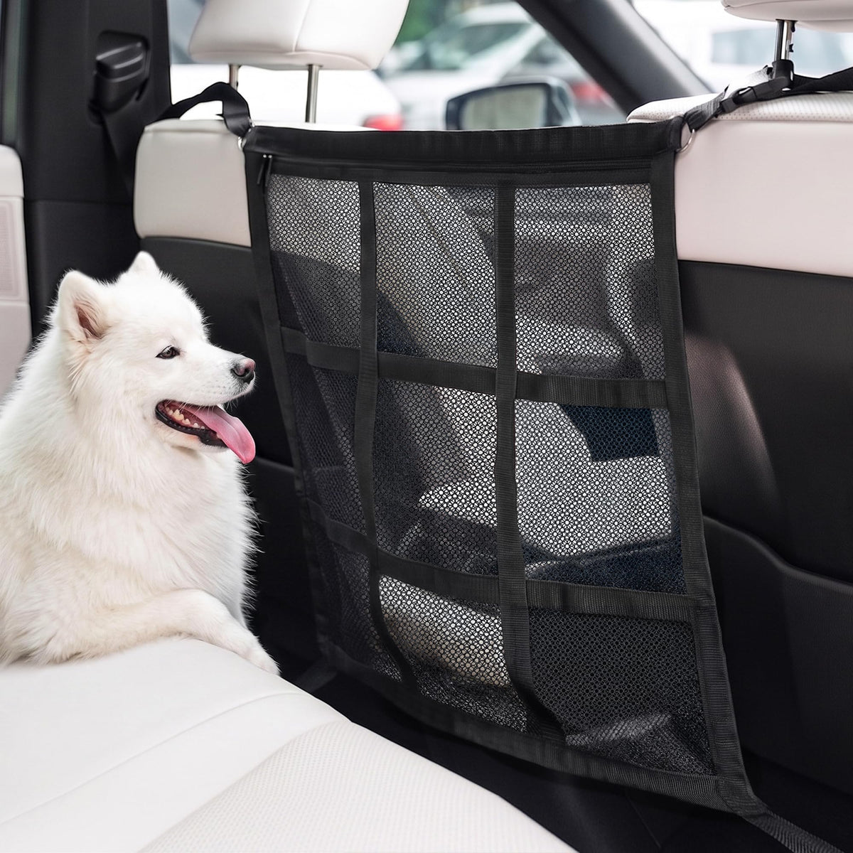 White dog sitting on the back seat behind a black double-layer mesh car barrier