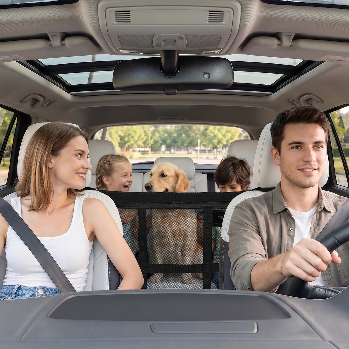 Family driving with a dog in the back behind the mesh car barrier