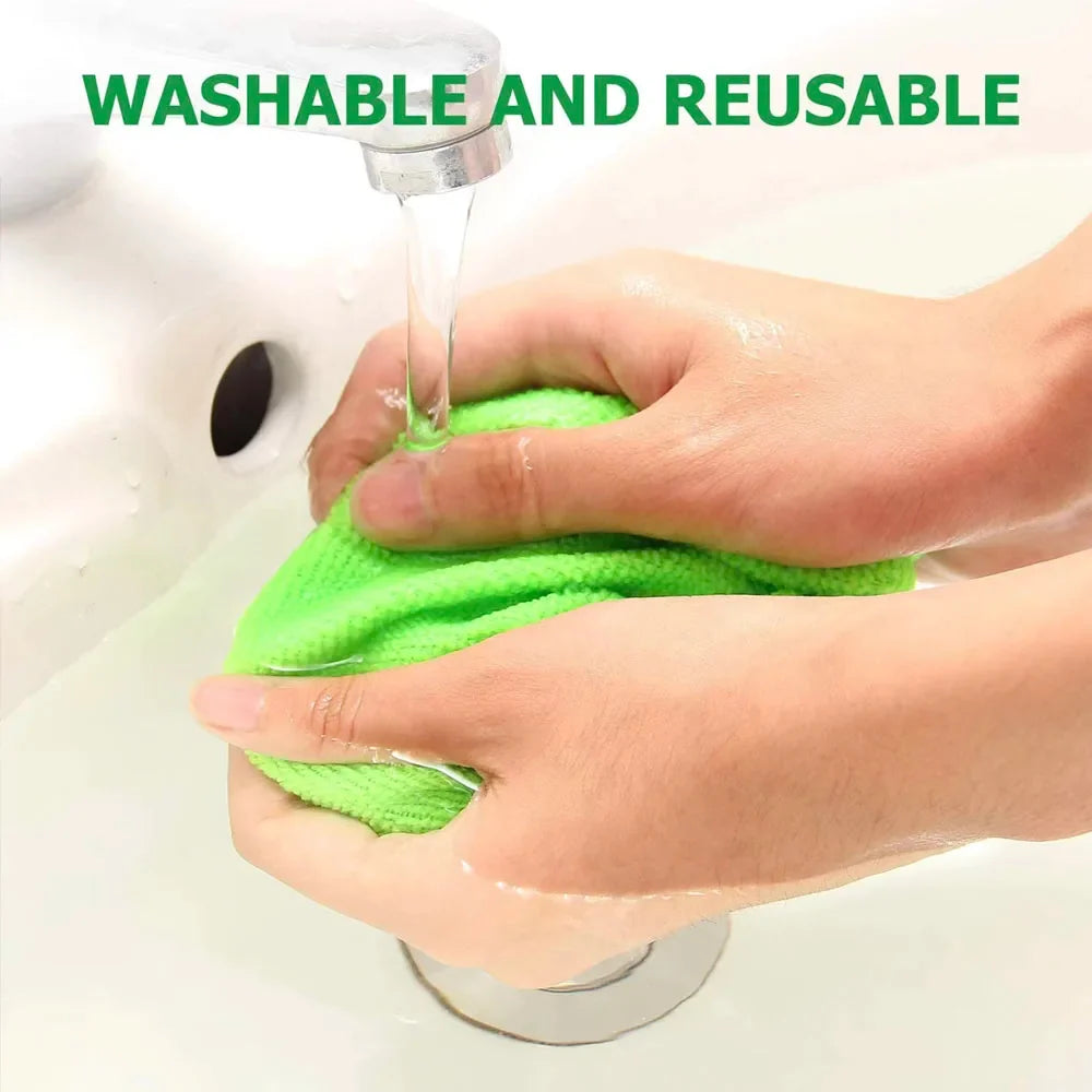 A bright green microfiber cloth being washed under running water from a faucet in a white sink, with hands holding and wringing the cloth. Green text at the top reads 'WASHABLE AND REUSABLE'.