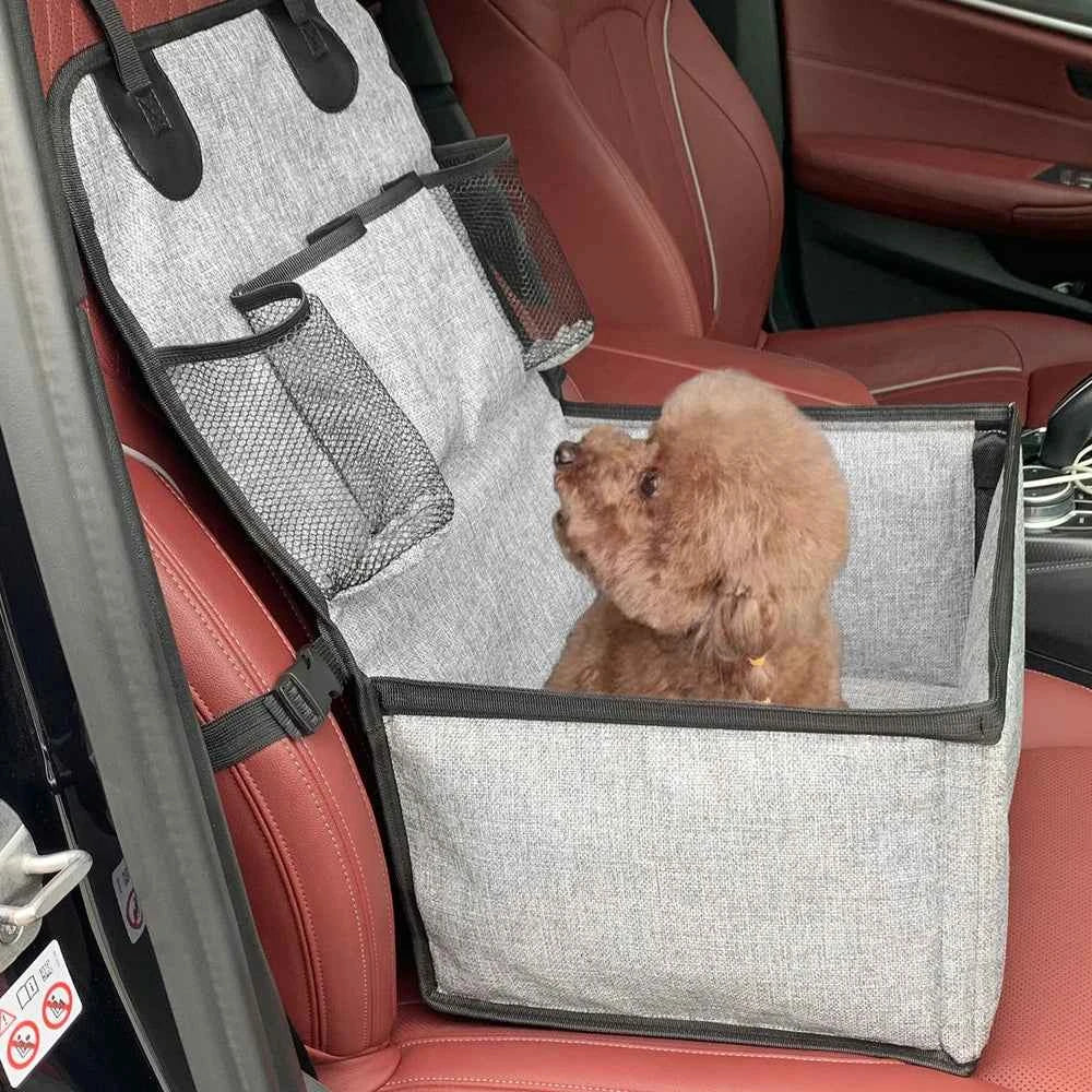 Pet car seat cover with a small brown dog inside on a red car seat.
