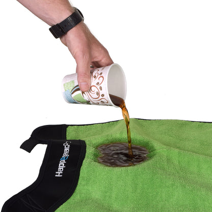 Liquid poured from a paper cup onto a green Happegear Happeseat cover