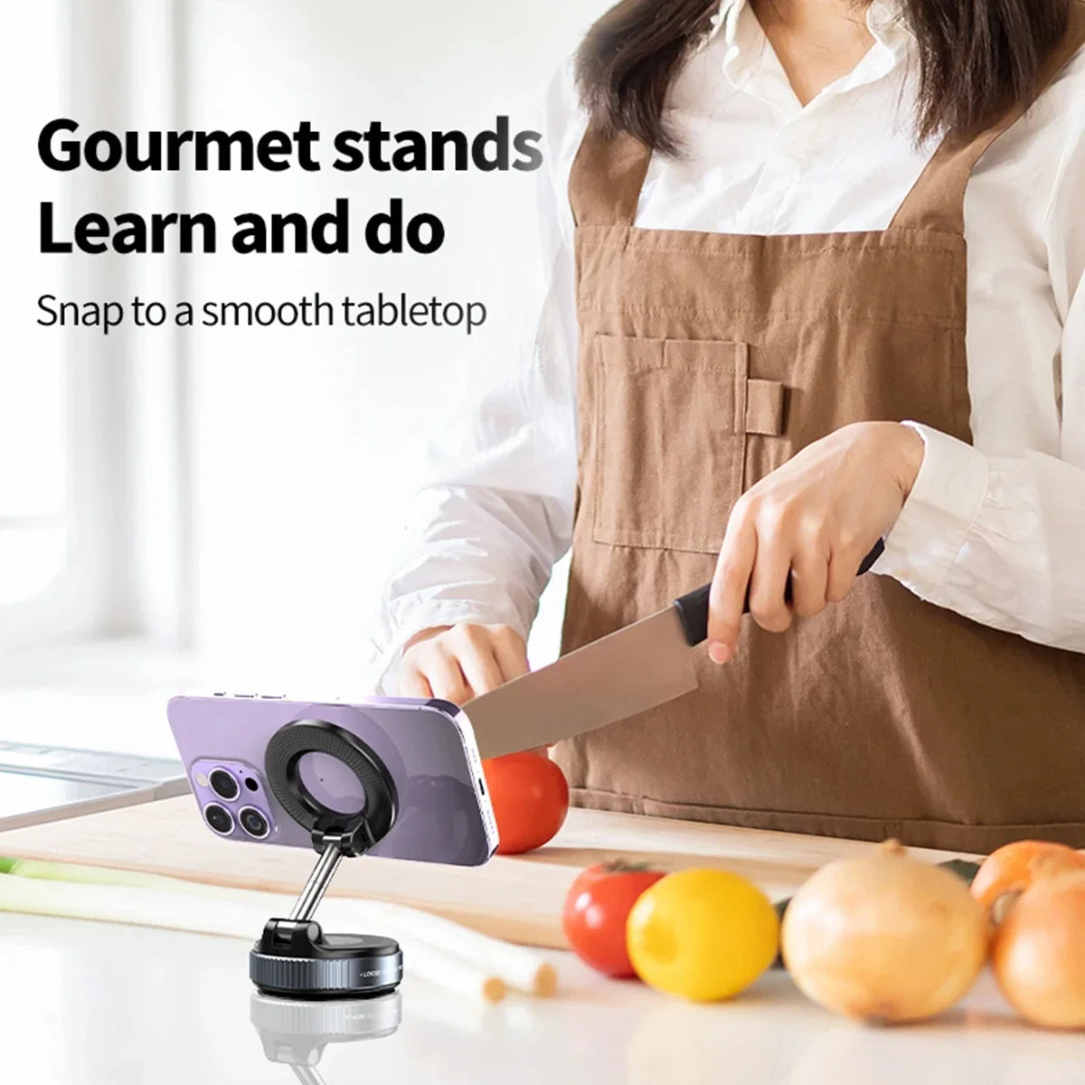 Person in a kitchen using a smartphone stand with text 'Gourmet stands Learn and do Snap to a smooth tabletop'.
