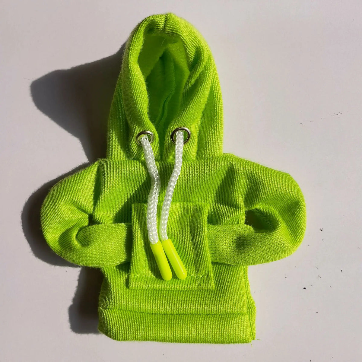 Green baby hoodie with a white drawstring on a light gray background