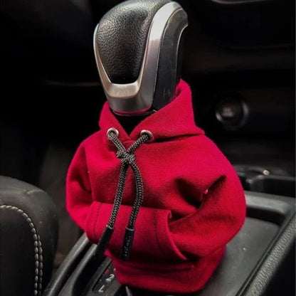 Car gear shift covered with a red hoodie inside a vehicle.