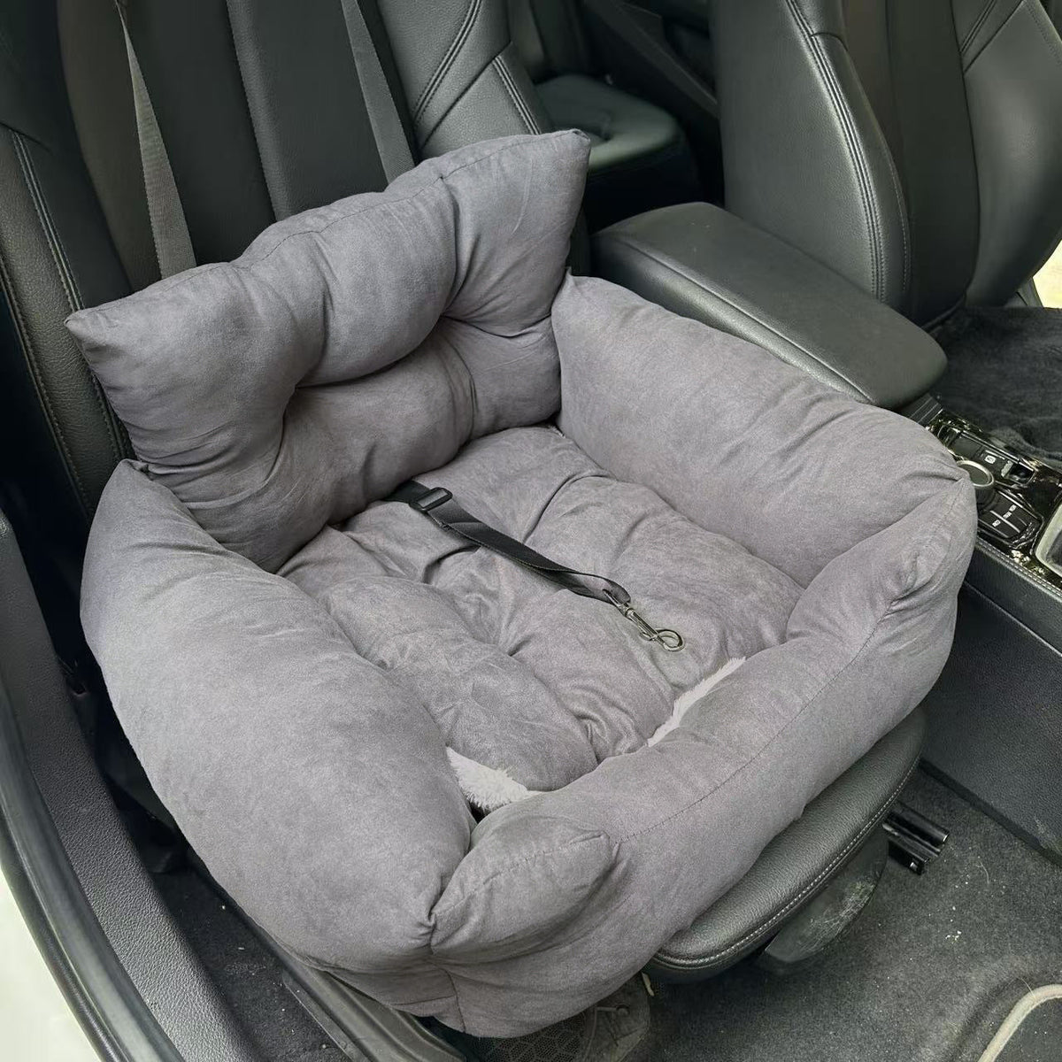 Empty dark gray plush dog seat bed on a car seat with built-in tether