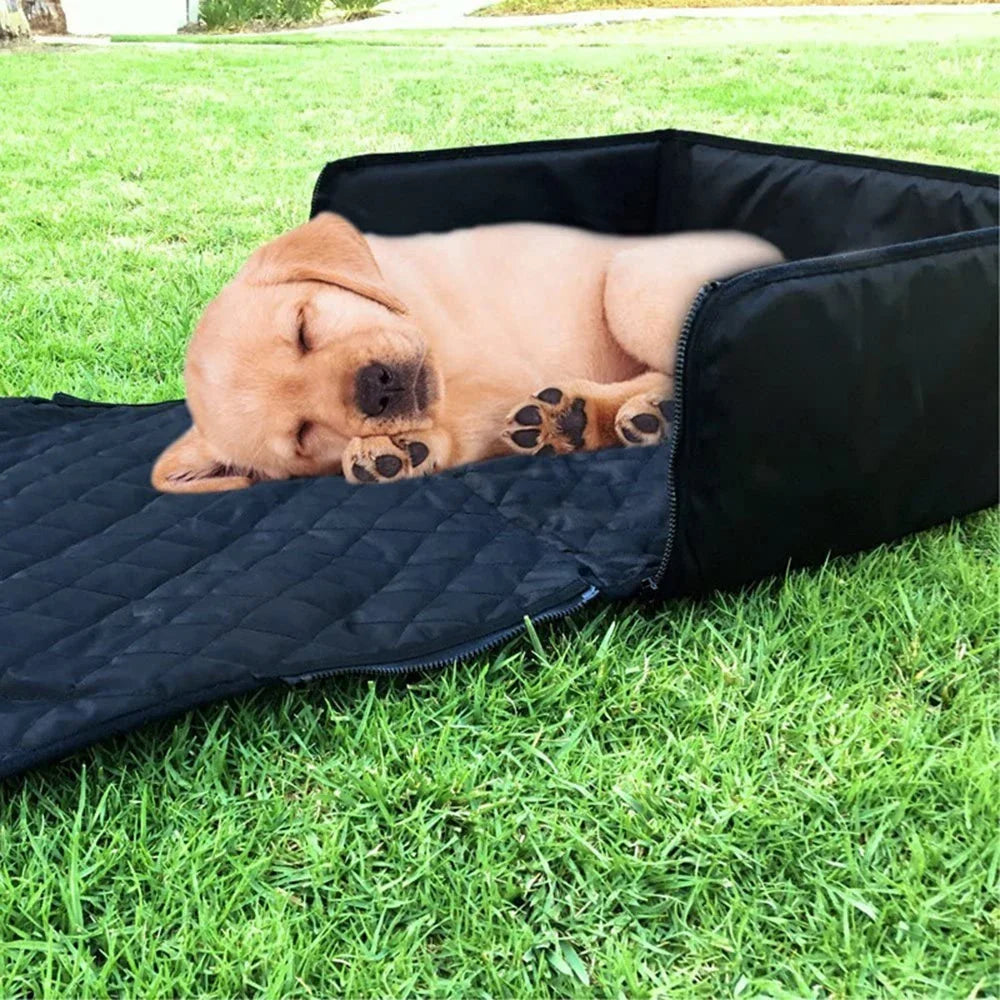 Puppy lying on the quilted seat cover unfolded flat on grass