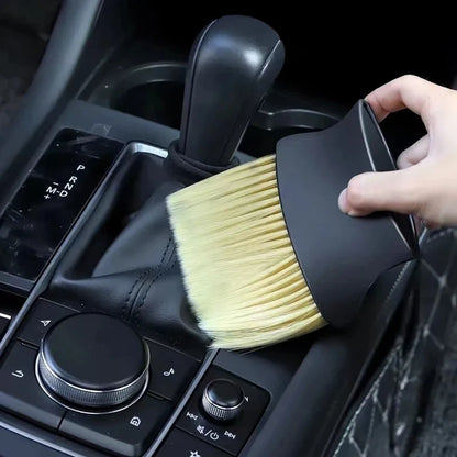 Car interior cleaning brush being used on a car dashboard.