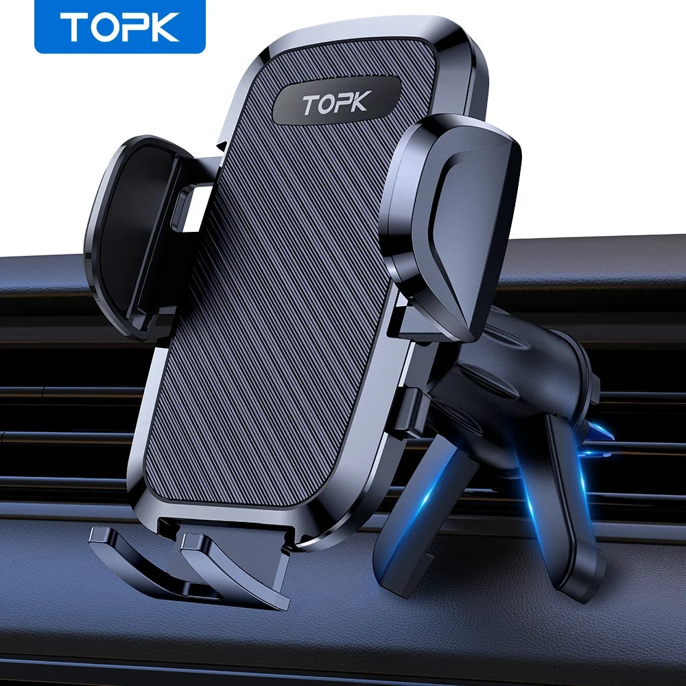 A black TOPK car phone mount with a textured front plate and adjustable clip arms, shown attached to a dashboard air vent. The product is photographed on a white-to-light-gray background with a blue TOPK logo in the top-left corner.